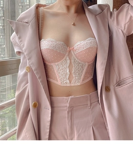 Dettaglio del corsetto in pizzo rosa abbinato a un completo con blazer coordinato