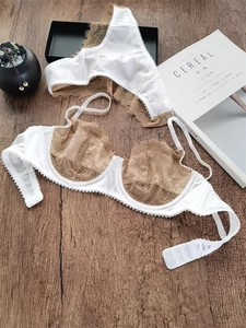 Platte lay-up van delicate witte kanten beha en slipset op een rustieke houten achtergrond