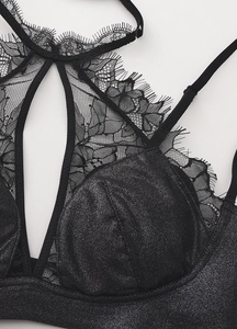 Macro detail of black eyelash lace trim and shimmering fabric on French bralette