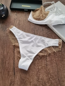 Platte weergave van een satijnen bh en kanten slip op een houten achtergrond