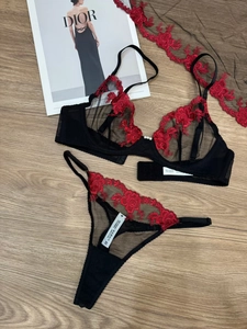 Detailansicht von schwarzem Dessous-Set mit roter Blumenstickerei und Perlenverzierung
