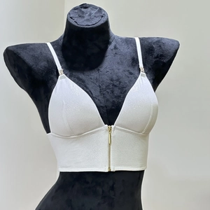 Close-up of white glitter fabric bralette featuring a front metal zipper and thin straps