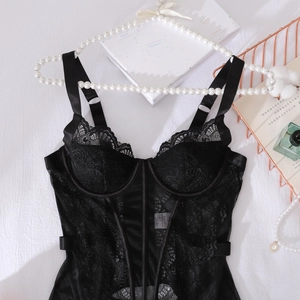 Vue détaillée de dessus du corset en dentelle noire avec baleines sur lit blanc