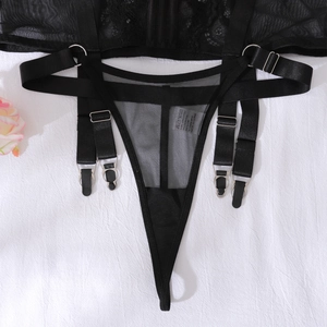 Détail d'un string en dentelle noire avec porte-jarretelles réglables et anneaux