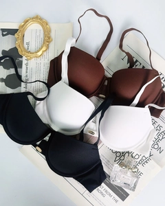 Dettaglio reggiseni push-up senza cuciture in caffè, bianco e nero con logo metallico