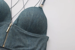 Detail of denim blue lace-free bra featuring front metal zipper and rhinestone accents