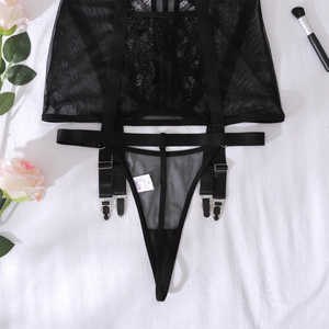 Détail d'un porte-jarretelles en dentelle florale noire avec sangles réglables et clips en métal