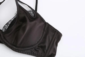Détail macro du soutien-gorge en satin noir avec dentelle cils et armatures de soutien