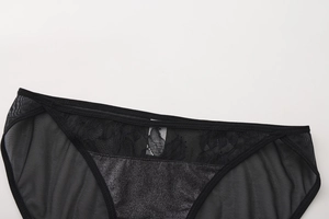 Detail of sheer black floral lace and mesh fabric with shimmering satin crotch panel