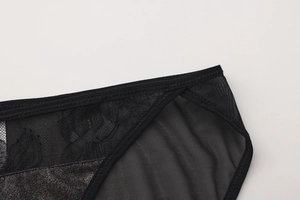 Detail shot of delicate black floral lace and mesh texture on women's lingerie