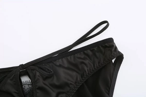 Vue macro de satin noir avec dentelle cils raffinée et détails de découpes ajourées