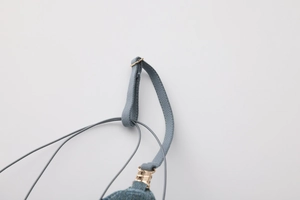 Detail of blue lingerie strap with golden ring fastener and elastic cord structure