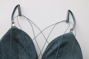 Detail of blue denim textured bra with thin straps, cross-lace design and gold metal clasps