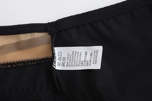 Detail of black lingerie wash label showing material composition and size M