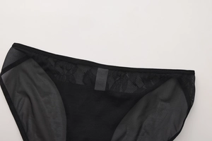 Detail of black lace and mesh fabric with delicate floral texture and sewing quality