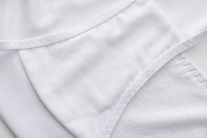 Macro shot of fine edge stitching on white cotton fabric for breathable low-waist panties