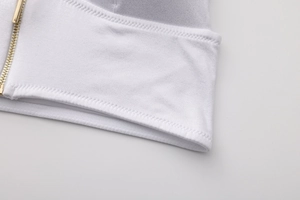 Close-up of white fabric detail featuring a premium golden metal front zipper closure