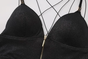 Detail of glittery fabric bra with front gold zipper and delicate crossover straps