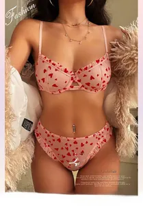 Close-up of pink lace lingerie set with red heart prints and delicate ruffle edges