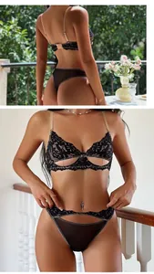 Dettaglio del ricamo in pizzo floreale nero e tessuto a rete su un set di lingerie