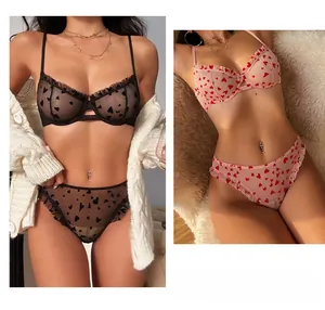 Detail of sheer lace lingerie set featuring heart embroidery and scalloped edges