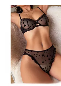 Close-up of black mesh lingerie set with flocked heart pattern and ruffled trim details