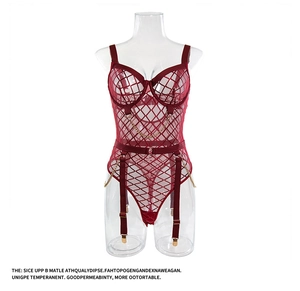 Detail van bordeauxrode mesh teddy lingerie met gouden kettingen en jarretels