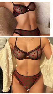Close-up of sheer black mesh lingerie set with red flocked heart print and ruffled trim