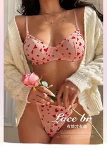 Détails d'un ensemble de lingerie en résille rose avec motifs cœurs rouges