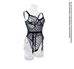 Detail van transparante mesh bodysuit met gouden kettingen en jarretels op pop