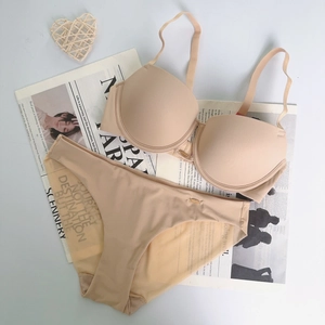 Set reggiseno e slip senza cuciture beige con ciondolo dorato e accenti decorativi