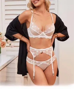 Detail von weißem Spitzen-Dessous-Set mit Herzstickerei und schwarzem Satin-Morgenmantel