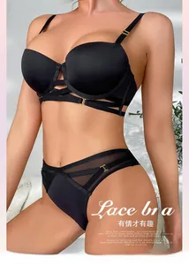 Detail van zwarte push-up bh-set met mesh, kruisbandjes en gouden metalen gespen