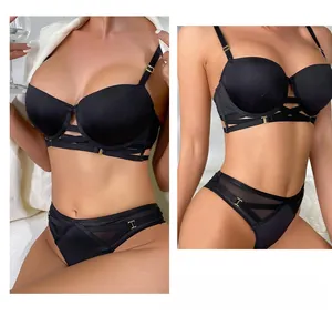 Detail van zwarte push-up bh-set met gekruiste bandjes en gouden metalen gespen