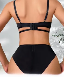 Detail achteraanzicht van een zwarte lingerieset met gekruiste bandjes en metalen gespen