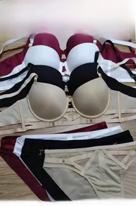 Platliggend detail van naadloze push-up bh's met gekruiste bandjes in vier kleuren