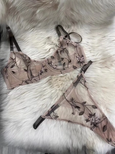 Close-up of delicate floral embroidery on pink mesh lace lingerie with steel underwire