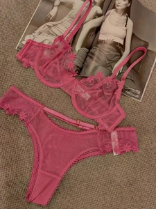 Detailed close-up of rose pink lace lingerie set with floral embroidery and mesh texture