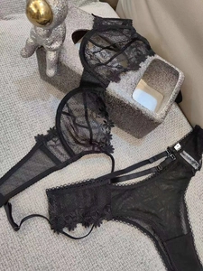 Detail of black embroidered lace lingerie set with semi-cup bra and floral textures