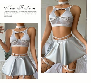 Close-up of heart-shaped cutout top and shiny pleated mini skirt with metal ring detail