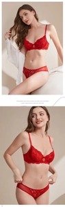 Detailed view of dark red lace bra set featuring floral patterns and a small pearl pendant