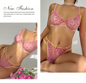 Detailansicht eines lila Spitzen-BH-Sets mit rosa Blumenstickerei und Wellenkanten