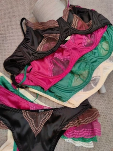 Detailed flat lay of lace and satin bras in diverse colors including black and red