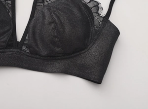 Dettaglio reggiseno in tessuto glitter nero con pizzo raffinato e spalline sottili