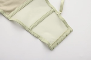 Dettaglio della chiusura a quattro file e rete traspirante sul reggiseno a corsetto verde