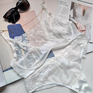 Close-up of white floral embroidery and sheer lace on a French style lingerie set