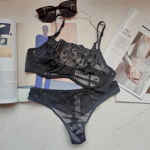 Detail view of black sheer lace lingerie set with floral embroidery on soft tulle fabric