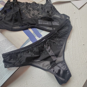 Detail shot of black lace lingerie set with floral embroidery and mesh texture