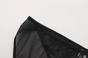 Dettaglio di ricami in pizzo nero e texture a rete su un reggiseno in stile francese