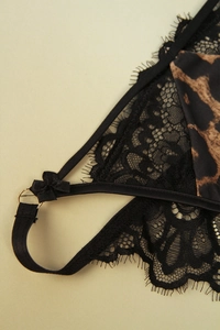 Close-up of black eyelash lace with leopard print fabric and a silk ribbon bow detail